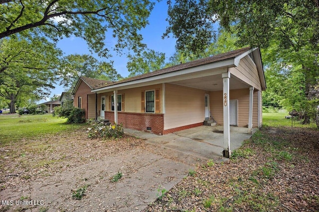 view of home's exterior featuring brick siding, driveway, a carport, and crawl space