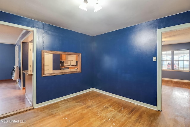 spare room featuring heating unit and wood-type flooring