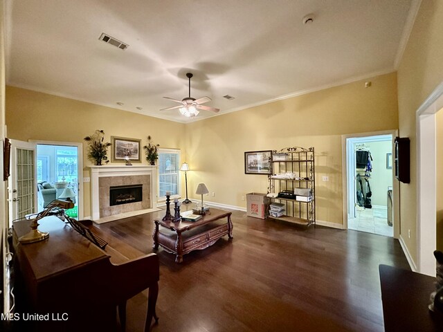 living area with a ceiling fan, baseboards, a tile fireplace, visible vents, and dark wood-type flooring