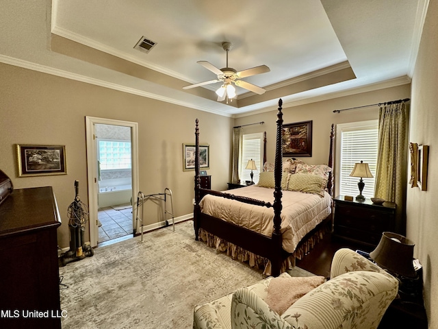 bedroom featuring visible vents, crown molding, ceiling fan, a tray ceiling, and carpet flooring
