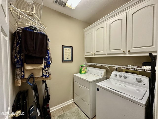 laundry area featuring washing machine and clothes dryer, cabinet space, baseboards, light tile patterned floors, and visible vents