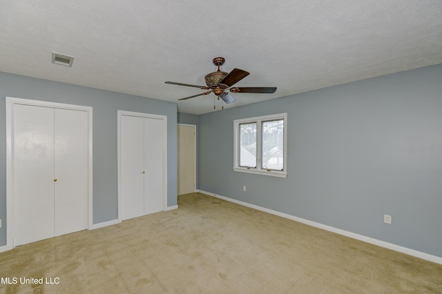 3099 E Fairway Dr, Brandon, MS 39047 - unfurnished bedroom with two closets, carpet floors, baseboards, and a ceiling fan
