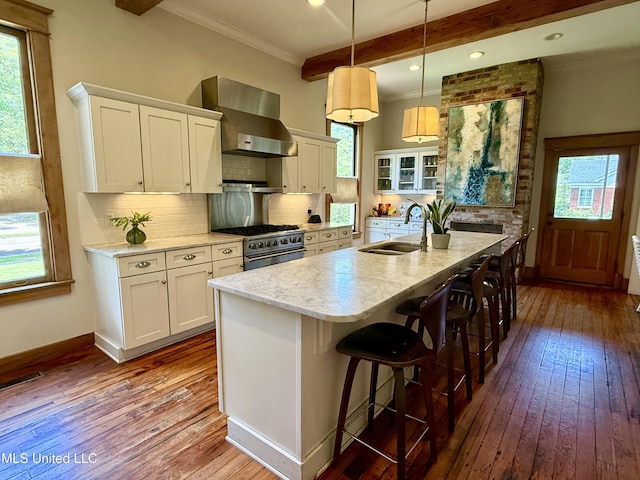 101 E E President, Greenwood, MS 38930 - kitchen with stainless steel range, wall chimney exhaust hood, dark wood-type flooring, ornamental molding, and backsplash