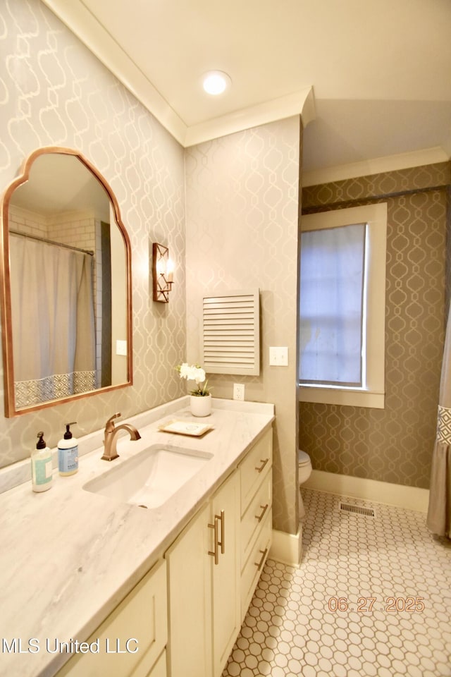 101 E E President, Greenwood, MS 38930 - bathroom with wallpapered walls, ornamental molding, and vanity