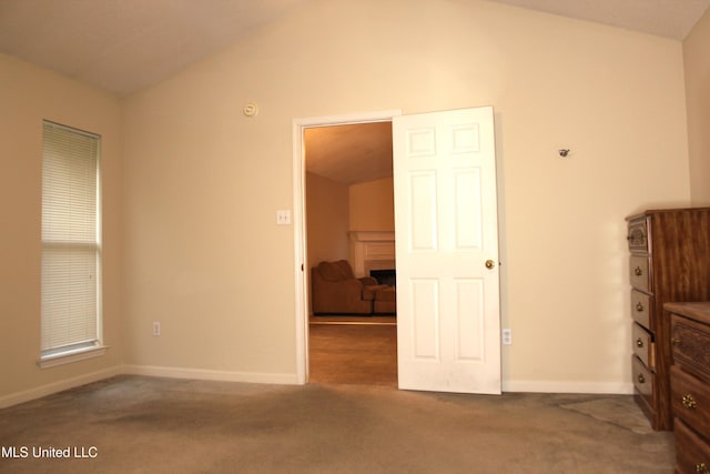 unfurnished bedroom with vaulted ceiling, carpet, and baseboards