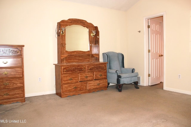 sitting room featuring carpet flooring, baseboards, and vaulted ceiling