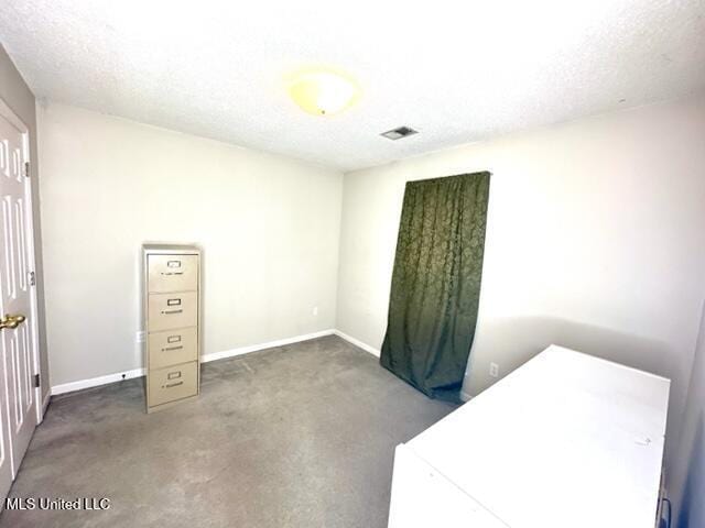 unfurnished bedroom featuring carpet floors, baseboards, washer / clothes dryer, and a textured ceiling