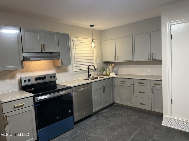 1529 Ticonderoga Dr, Southaven, MS 38671 - kitchen with stainless steel appliances, under cabinet range hood, a sink, gray cabinets, and decorative backsplash
