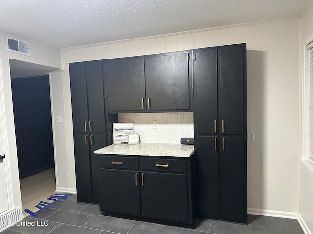 1529 Ticonderoga Dr, Southaven, MS 38671 - kitchen with tasteful backsplash, tile patterned floors, baseboards, dark cabinetry, and a textured ceiling