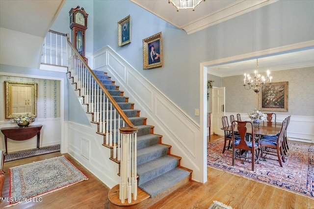 350 Whitfield Rd, Brandon, MS 39042 - stairway featuring a chandelier, a wainscoted wall, a decorative wall, crown molding, and wood finished floors