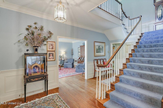 350 Whitfield Rd, Brandon, MS 39042 - staircase featuring ornamental molding, a chandelier, wood finished floors, wainscoting, and a decorative wall