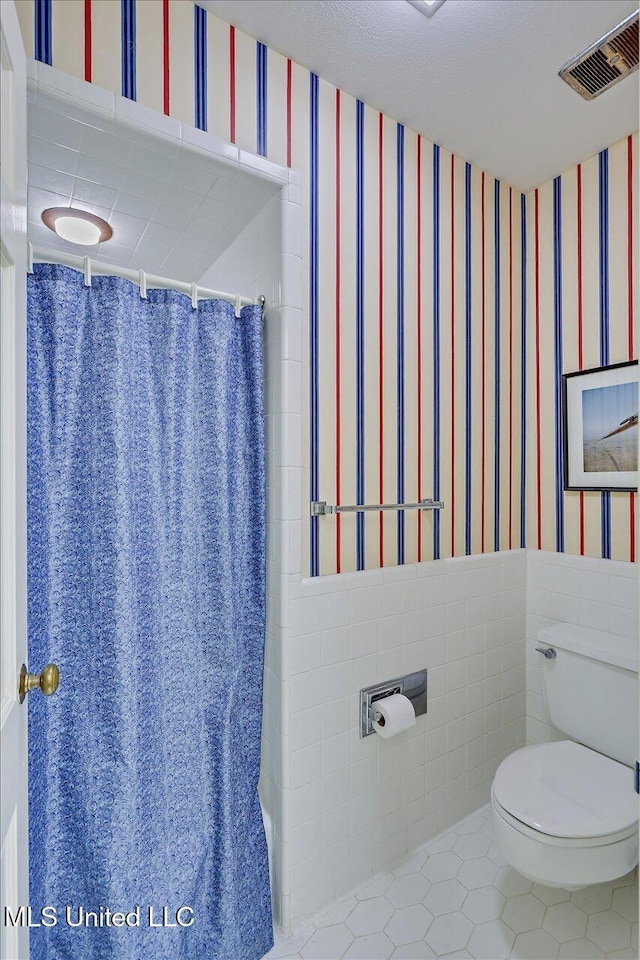 350 Whitfield Rd, Brandon, MS 39042 - bathroom with wallpapered walls, tile patterned floors, a wainscoted wall, curtained shower, and tile walls