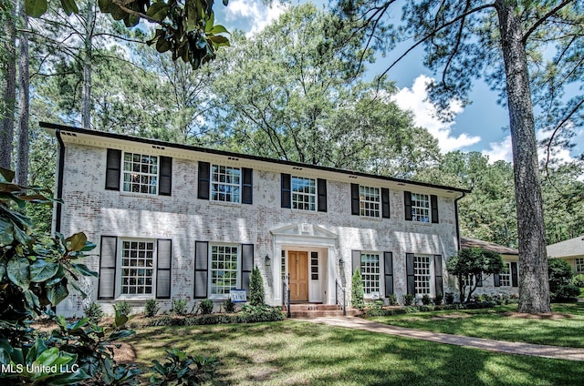 colonial inspired home with a front lawn