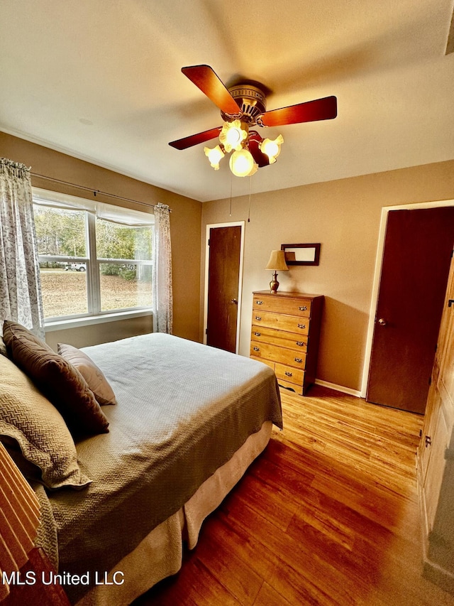 bedroom with ceiling fan and wood-type flooring