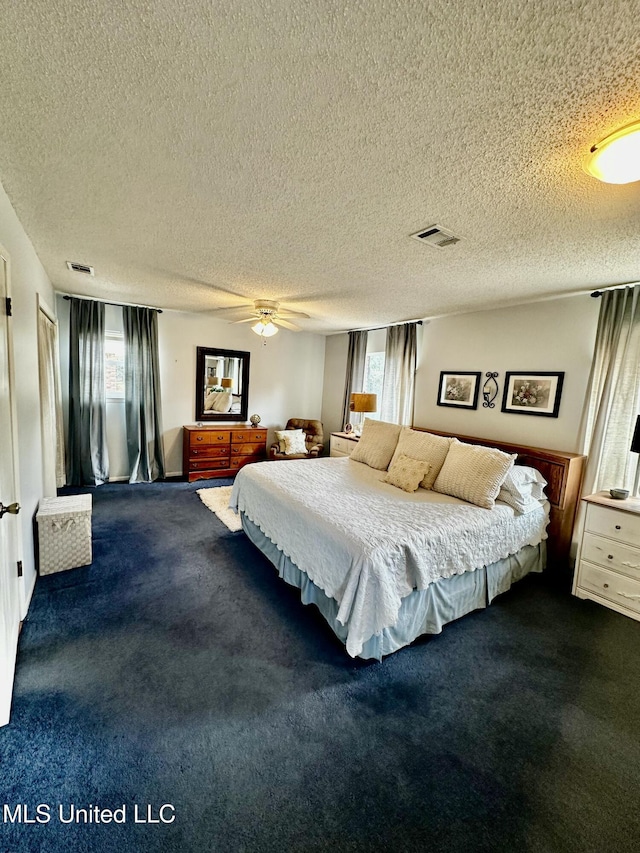 carpeted bedroom featuring multiple windows, ceiling fan, and a textured ceiling