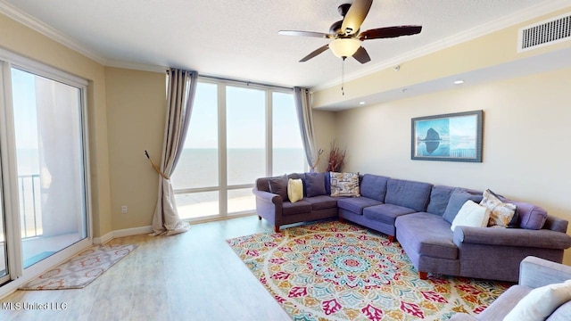 1200 Beach Dr Unit 806, Gulfport, MS 39507 - living area featuring wood finished floors, healthy amount of natural light, ornamental molding, a ceiling fan, and baseboards