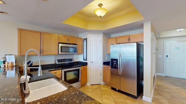 1200 Beach Dr Unit 806, Gulfport, MS 39507 - kitchen with appliances with stainless steel finishes, a sink, a tray ceiling, light tile patterned floors, and ornamental molding