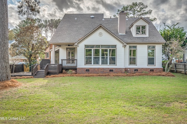 back of house featuring a lawn and a deck