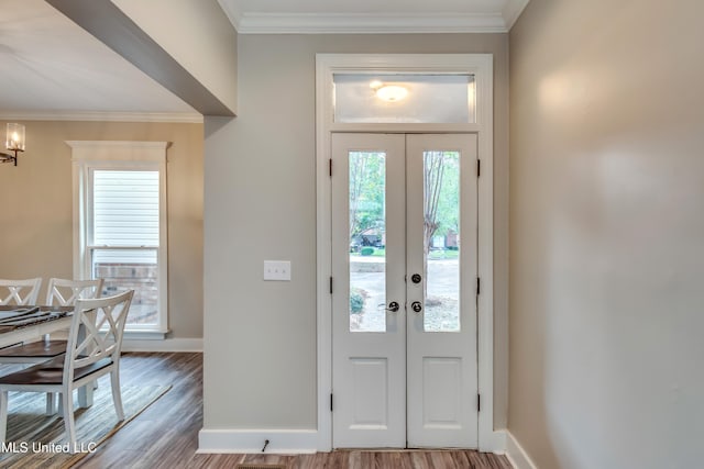 entrance foyer featuring light wood-type flooring, french doors, and crown molding