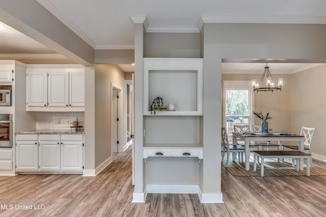 kitchen featuring white cabinets, hanging light fixtures, oven, light stone countertops, and light wood-type flooring