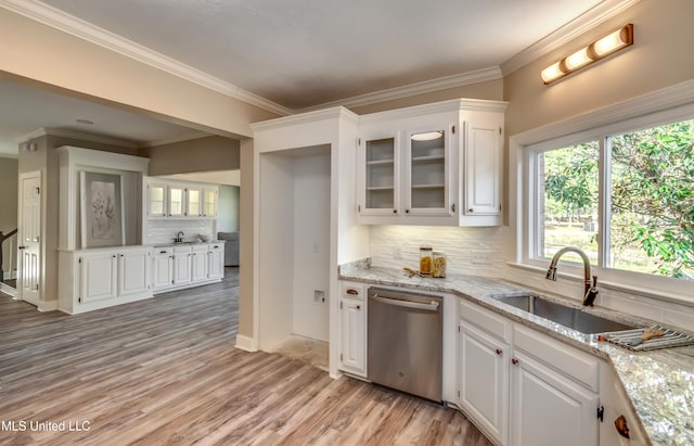 kitchen featuring sink, stainless steel dishwasher, light stone countertops, white cabinetry, and light hardwood / wood-style flooring