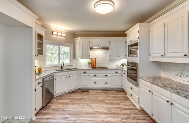 kitchen featuring white cabinetry, appliances with stainless steel finishes, sink, and light stone counters