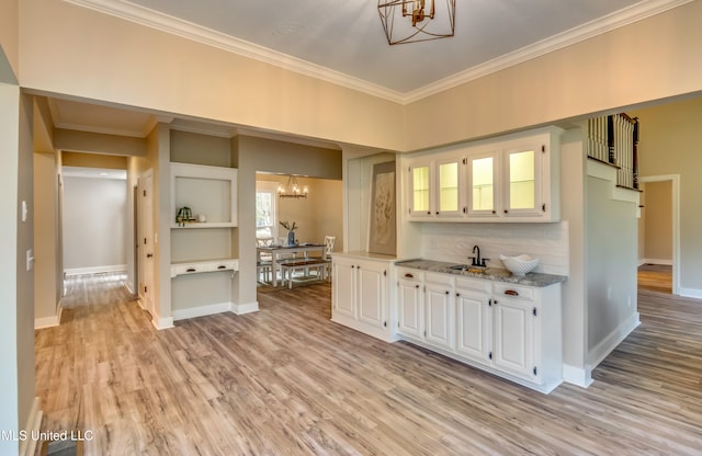 kitchen featuring white cabinetry, sink, light wood-type flooring, and light stone counters