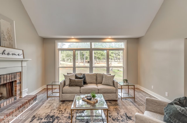 living room with a brick fireplace, light wood-type flooring, and vaulted ceiling