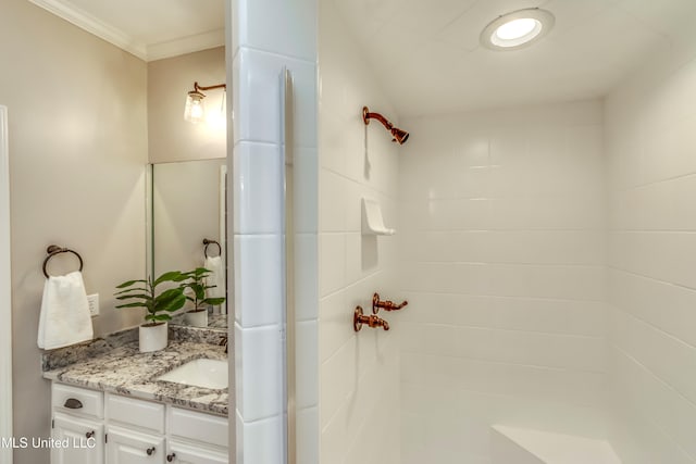 bathroom featuring vanity, a tile shower, and crown molding