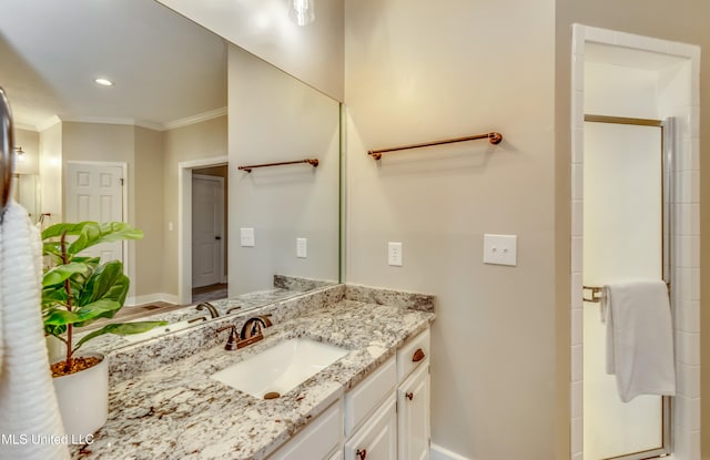 bathroom featuring walk in shower, vanity, and crown molding