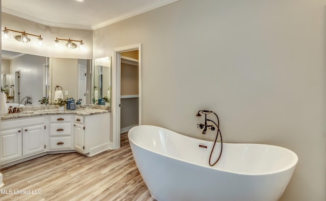 bathroom featuring a bathtub, vanity, wood-type flooring, and crown molding