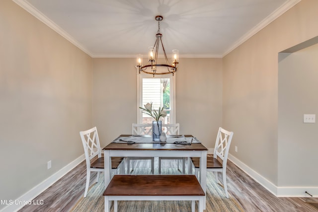 unfurnished dining area with hardwood / wood-style flooring, crown molding, and an inviting chandelier