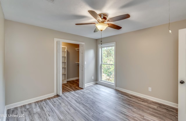 unfurnished room with light wood-type flooring and ceiling fan