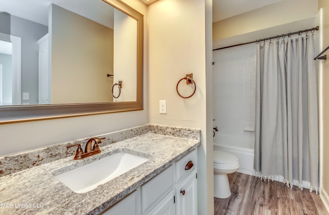 full bathroom featuring toilet, vanity, shower / bath combo with shower curtain, and hardwood / wood-style floors