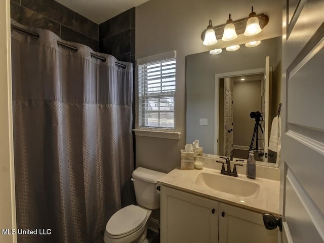 bathroom featuring a shower with shower curtain, vanity, and toilet