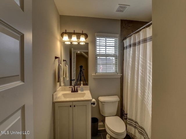 bathroom featuring tile patterned flooring, vanity, toilet, and curtained shower