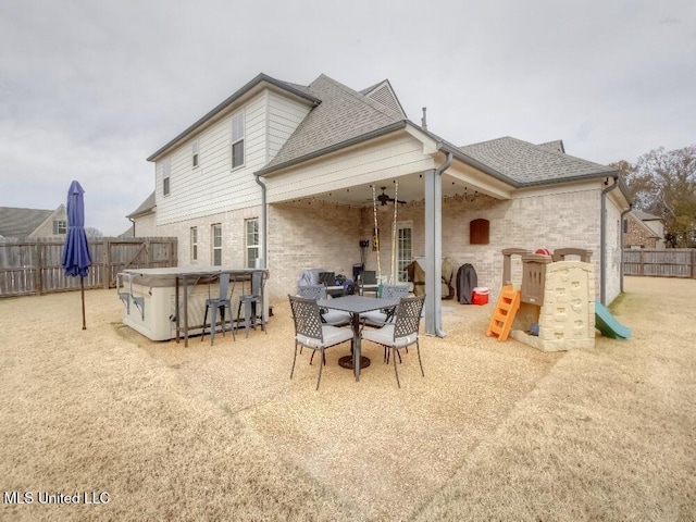 back of house featuring a patio and a hot tub