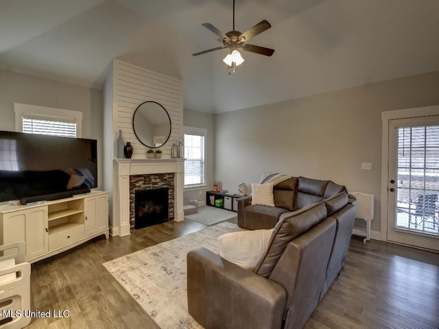 living room featuring a healthy amount of sunlight, lofted ceiling, and dark wood-type flooring