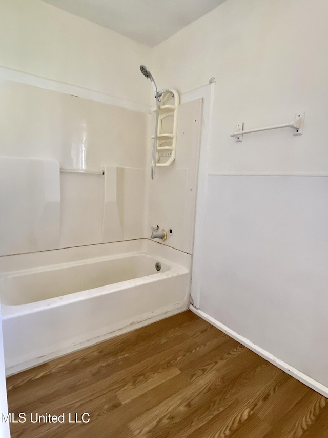 bathroom featuring washtub / shower combination and wood finished floors