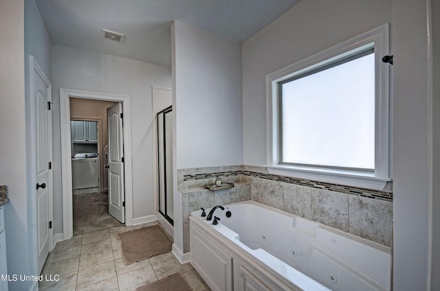 236 Cooper Ln, Canton, MS 39046 - full bath featuring washer / clothes dryer, a jetted tub, baseboards, a shower stall, and visible vents