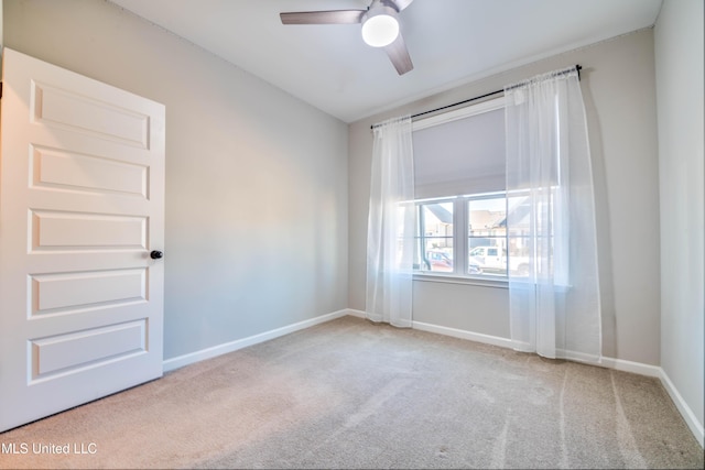 carpeted spare room featuring ceiling fan