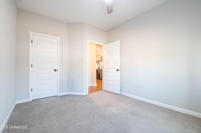 unfurnished bedroom featuring light colored carpet and ceiling fan