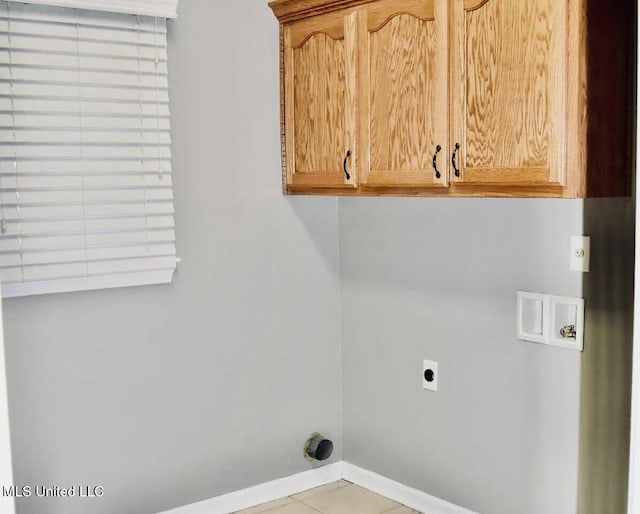 clothes washing area with washer hookup, cabinets, hookup for an electric dryer, and light tile patterned floors