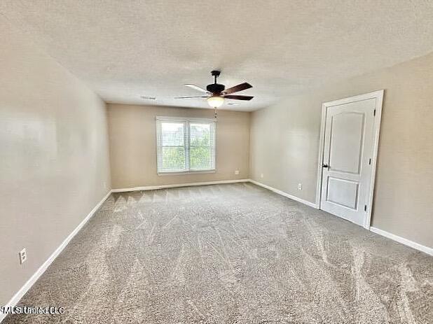 spare room featuring a textured ceiling, ceiling fan, and carpet floors