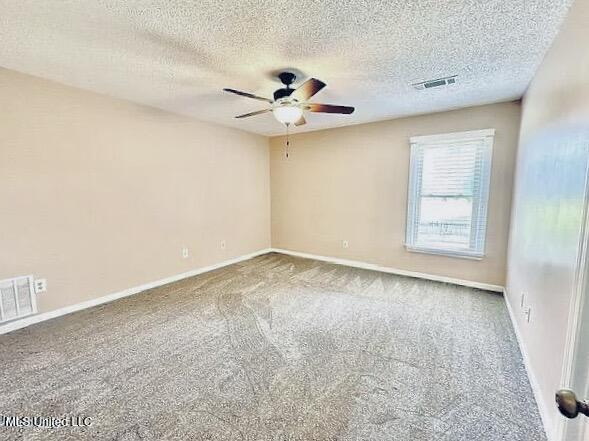 unfurnished room featuring a textured ceiling, ceiling fan, and carpet