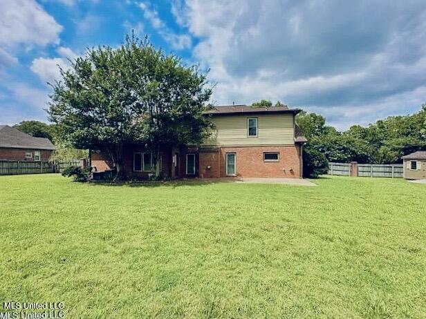 back of property featuring a lawn