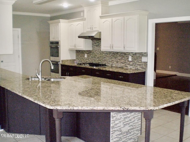 kitchen with sink, appliances with stainless steel finishes, a breakfast bar area, and white cabinetry