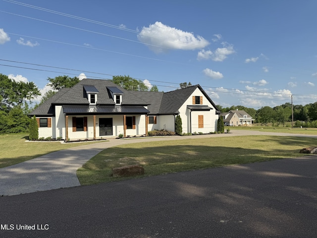 modern inspired farmhouse with a standing seam roof, a porch, and a front lawn