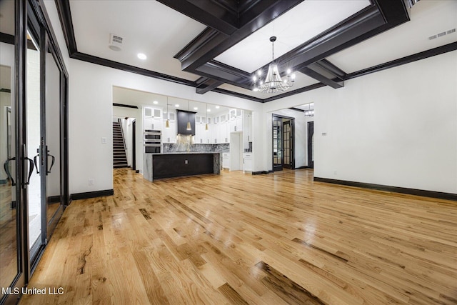unfurnished living room with visible vents, crown molding, baseboards, light wood-type flooring, and a chandelier