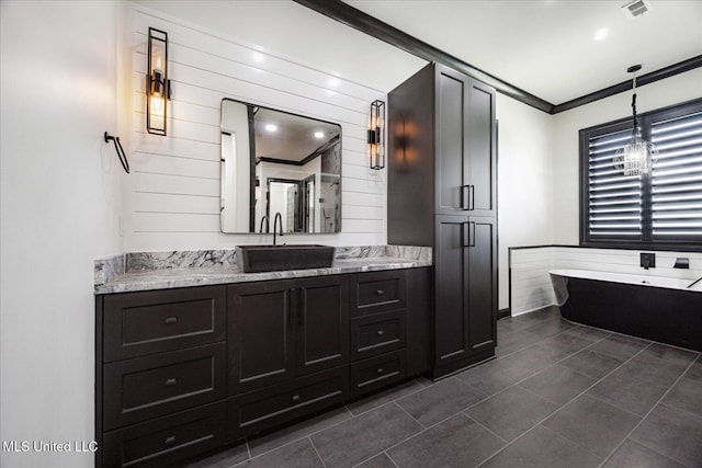 full bathroom featuring visible vents, a freestanding bath, crown molding, vanity, and tile patterned floors